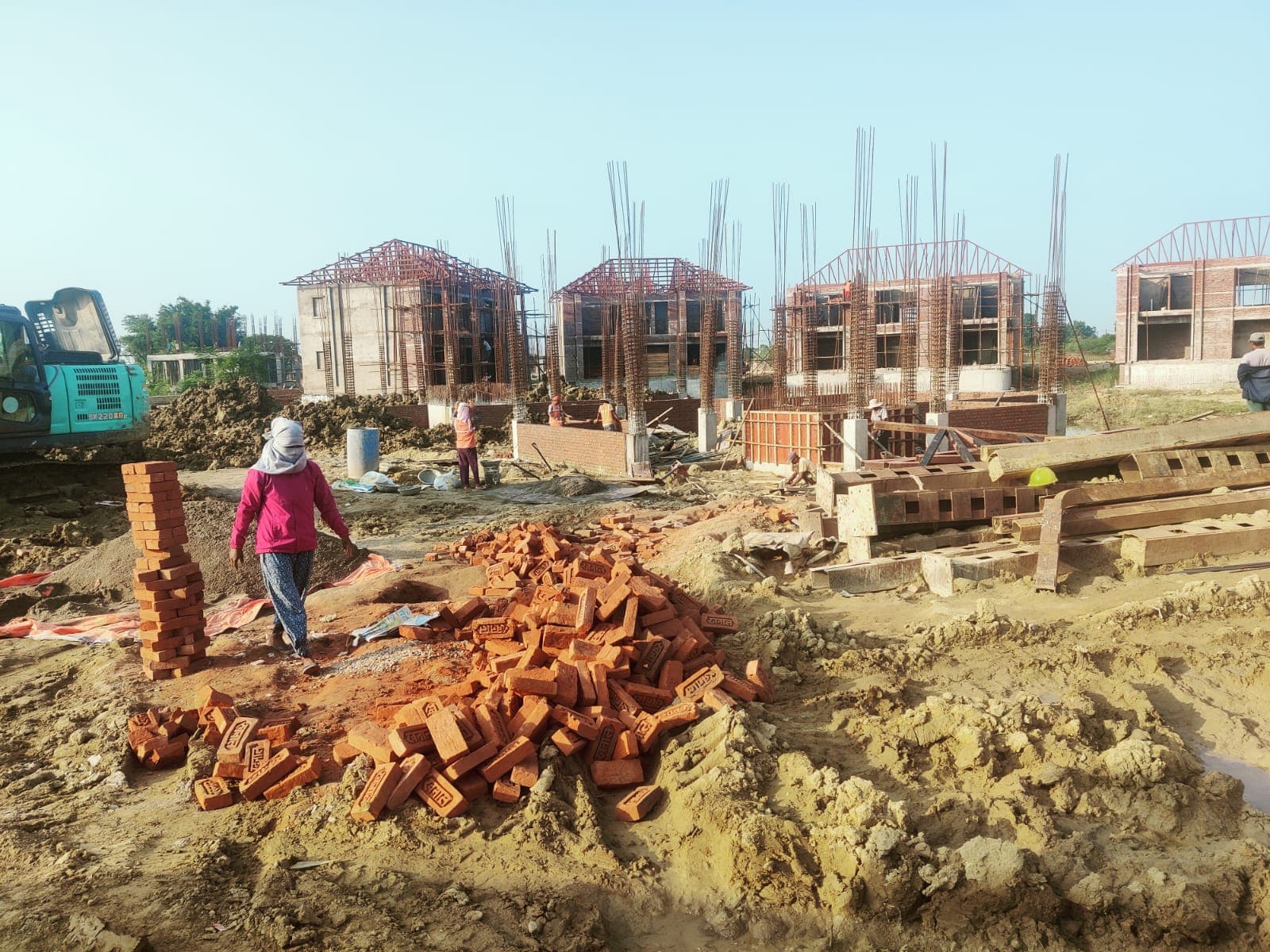 Workers and building materials among several masonry structures under construction